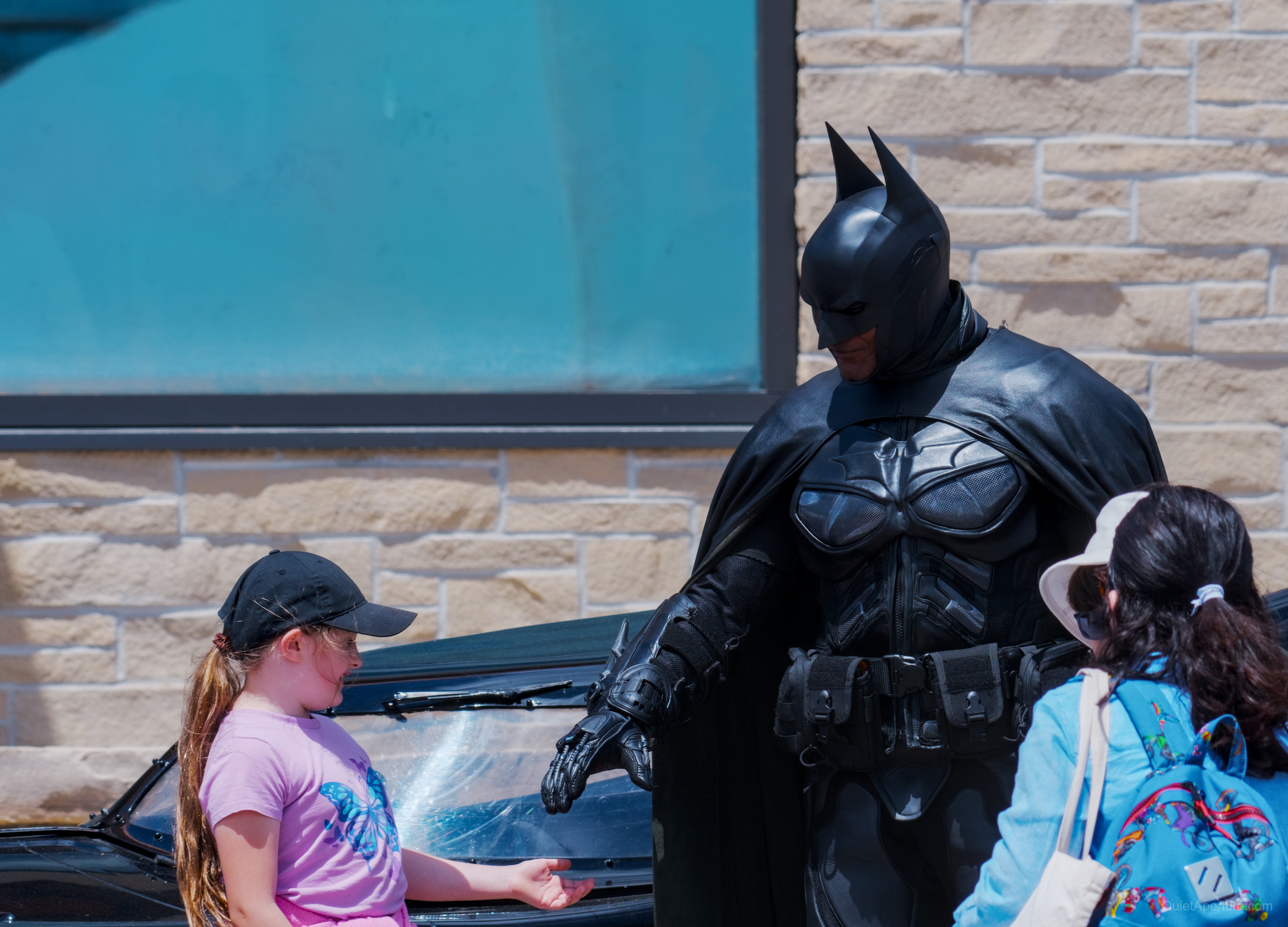 A costumed character greeting visitors beside a black car at the Bread & Honey Festival, frame 04.
