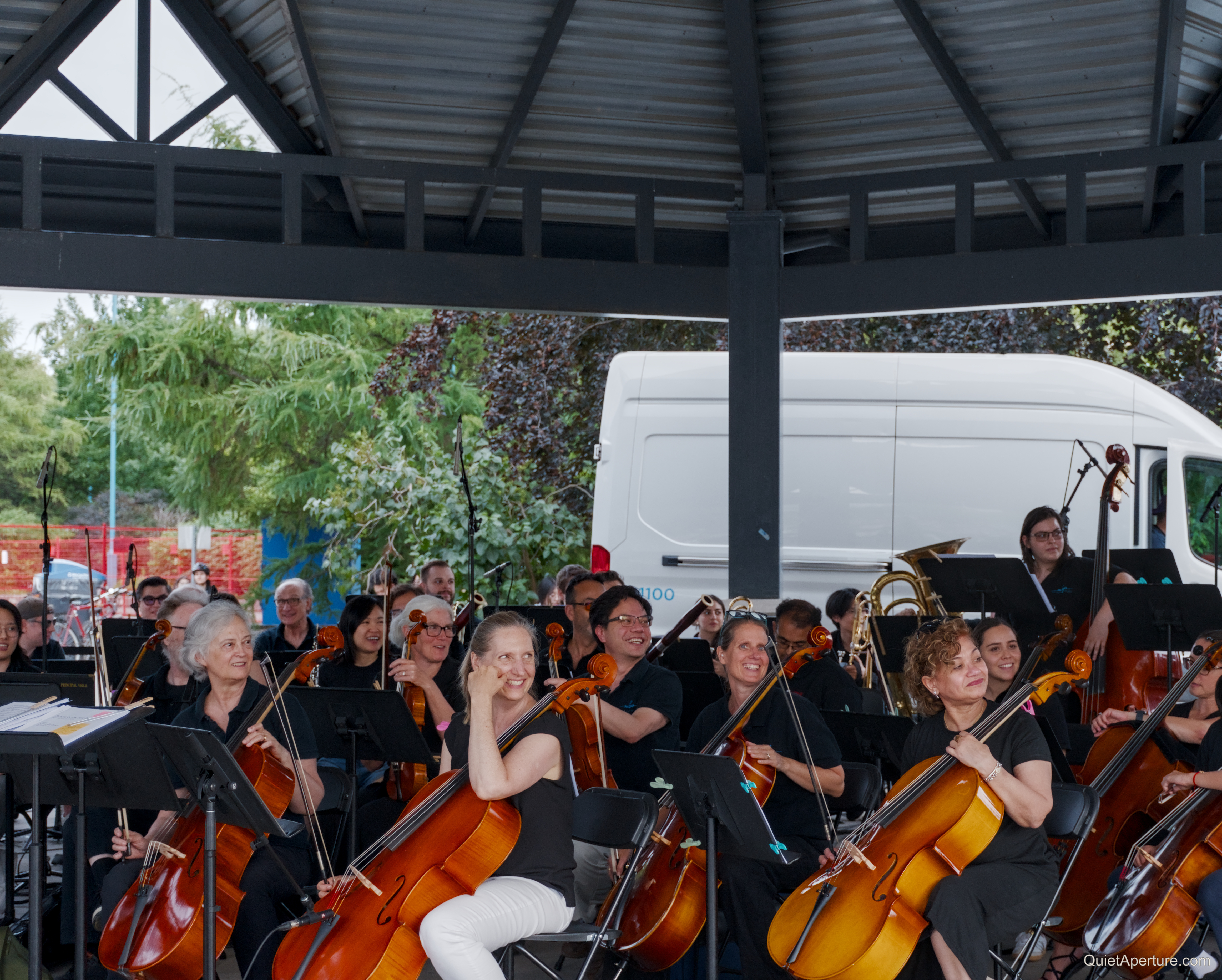 Mississauga Symphony Orchestra musicians performing under a park pavilion.